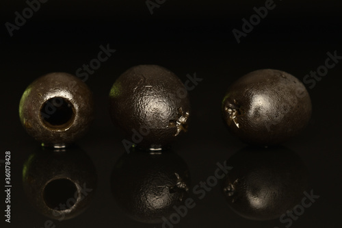 Pickled spicy black olives  close-up  on a black background.