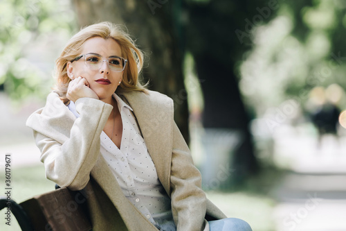 woman sitting on a park bench thinking, worried