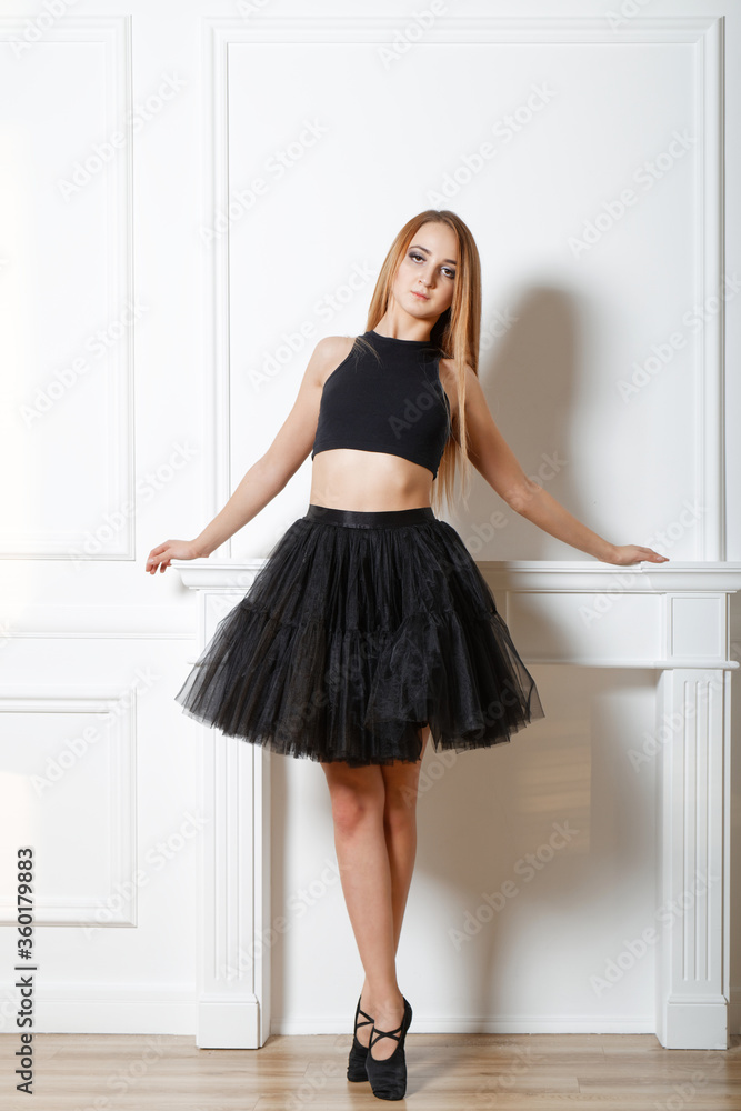 Young girl - ballet dancer in black tutu doing exercises in studio Young girl - ballet dancer in black tutu doing exercises in studio