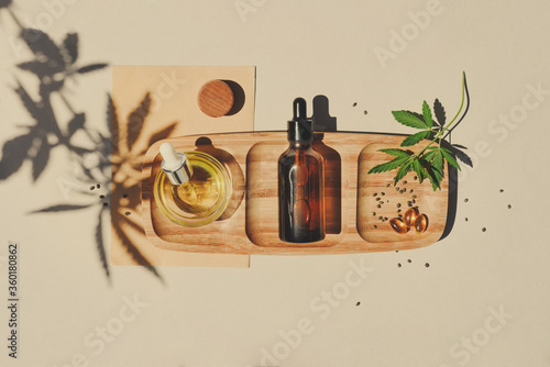 CBD oil, tincture with a pipette on a beige background with hemp leaves. Concept medical cannabis Trendy Flat Lay Minimalism photo