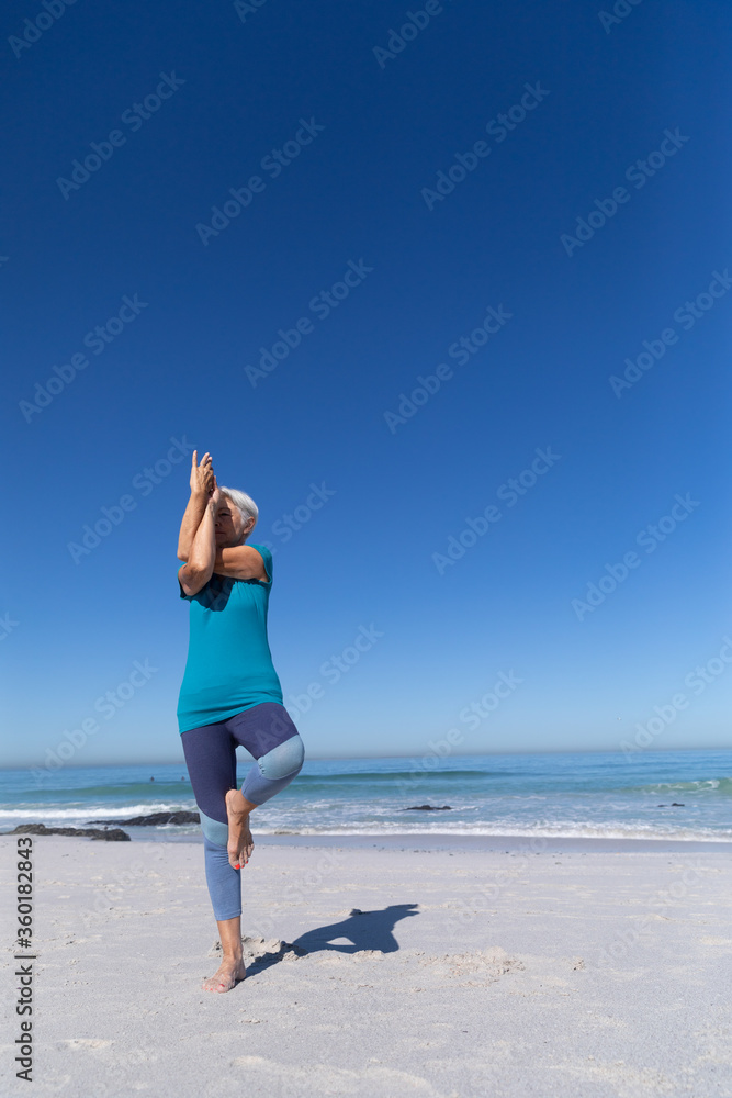 Senior Caucasian woman practicing yoga at the beach. Senior Caucasian woman practicing yoga at the beach.