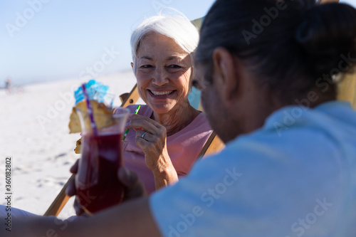 Senior Caucasian couple sitting on deck chairs at the beach.