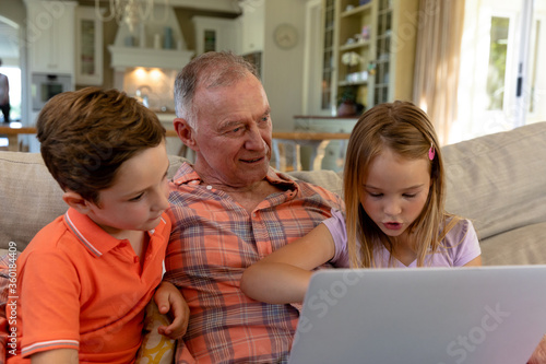 Grandfather and grandchildren at home in the living room