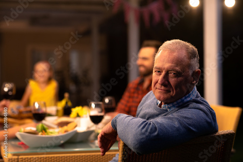 Senior Caucasian man sitting at the table and looking at camera