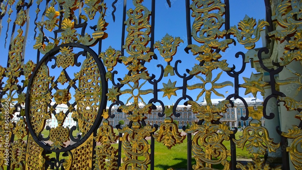 Ornament elements of the Golden Gate of the Catherine Palace in Pushkin, Russia. Wrought iron ancient fence after renovation. Historical architecture. Gold plated decorative elements. Background. 