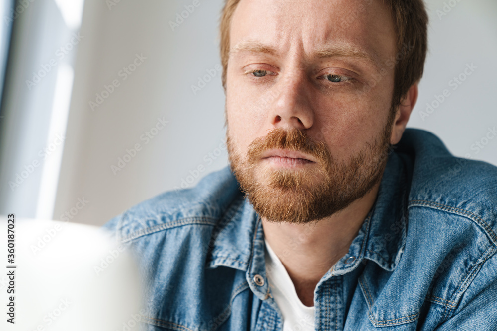 Photo of brooding handsome man working with laptop Photo of brooding handsome man working with laptop