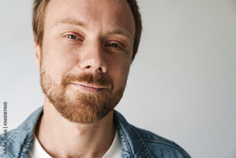 Fototapeta premium Photo of joyful young man with red hair posing and smiling on camera