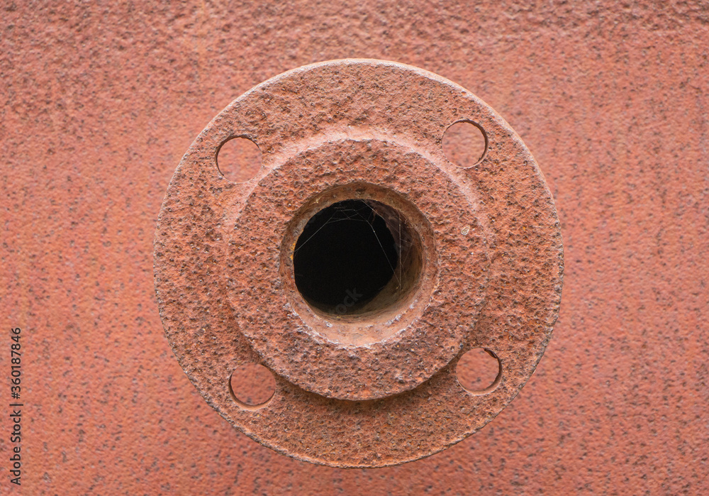 The rusty element of the old construction hole is overgrown with cobwebs. The spare part. Round iron disk with screw cuts. Hight quality