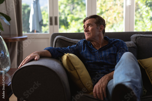 Senior Caucasian man enjoying his time at home and sitting on a couch
