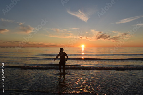 Katwijk aan Zee / The Netherland - June 20 2020: Local sports fishermen are walking in the sea, trawling their fishnet along the beach fishing for sole, in the evening at sun set.  © Bart