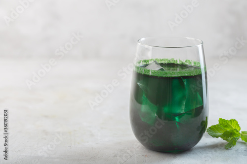 Green drink prepared with single celled green algae chlorella. Detox superfood in the glass with copy space