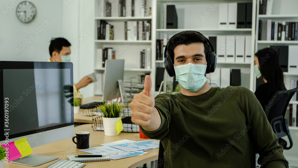 businessman wearing mask and show thumb up in office, ready to work concept
