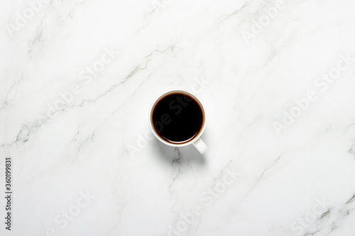 Cup with coffee on a marble table. Concept breakfast, black coffee, coffee for the night, insomnia. Flat lay, top view