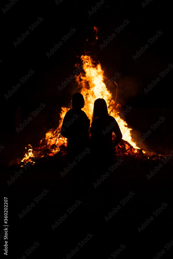 Young couple in front of a giant fire