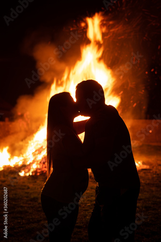 Pregnant couple in front of a giant fire