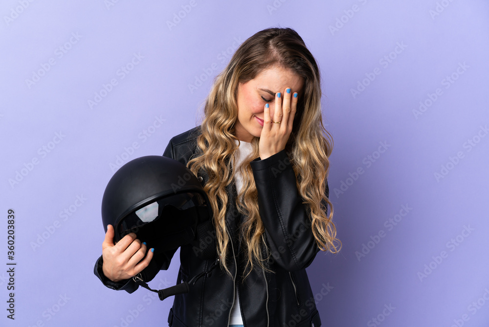 Young Brazilian woman holding a motorcycle helmet isolated on purple background with tired and sick expression Young Brazilian woman holding a motorcycle helmet isolated on purple background with tired and sick expression
