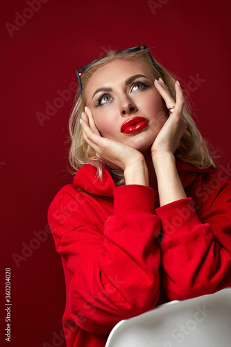 gorgeous blonde woman with sunglasses on red background.