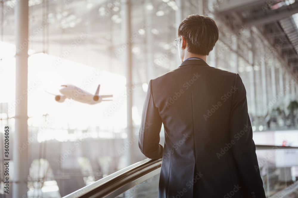 Φωτογραφία Businessman moving to terminal gate by escalator for check in boarding with luggage at the airport
