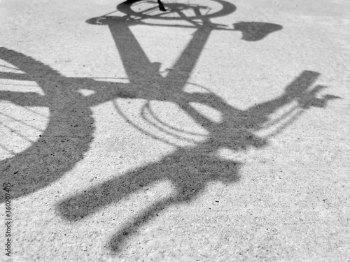 Light and shadow of the bicycle on the road surface. photo