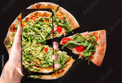Order pizza using mobile and food delivery. Smartphone on black background. Online food delivery concept. Virtual reality