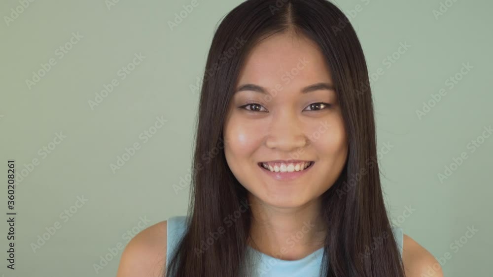 portrait close-up. cute asian girl looking at the camera and smiling with a wide smile 4 K portrait close-up. cute asian girl looking at the camera and smiling with a wide smile 4 K