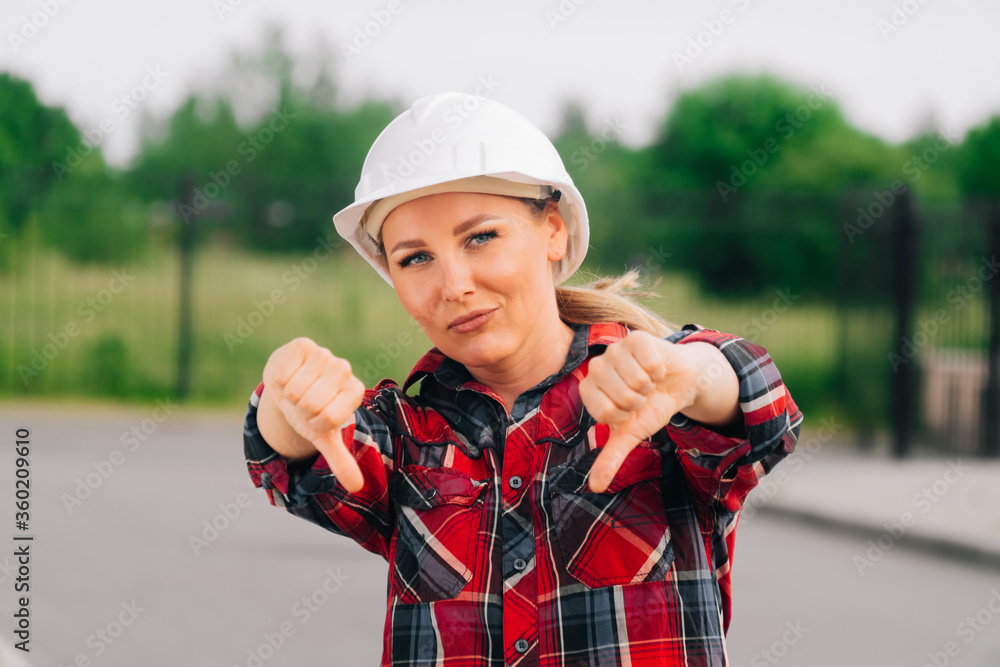 Sad woman builder architect showing hands sign of bad quality. Sad woman builder architect showing hands sign of bad quality.