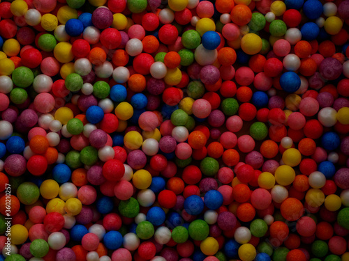 Dark background texture of multicolored foam balls