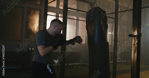 Male boxer punching bag at a boxing studio © supamotion