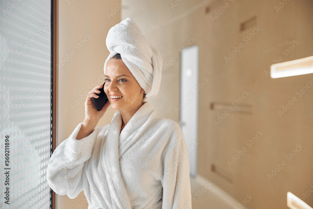 Contented woman having a phone conversation indoors Contented woman having a phone conversation indoors