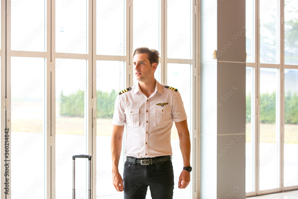 portrait of a young man pilot standing by window portrait of a young man pilot standing by window