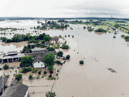 Aerial view of the flooded village of Halych, Prykarpattia, Western Ukraine. The flood on the Dniester River caused a natural disaster. Streets, roads, parks and houses in dirty rainwater photo