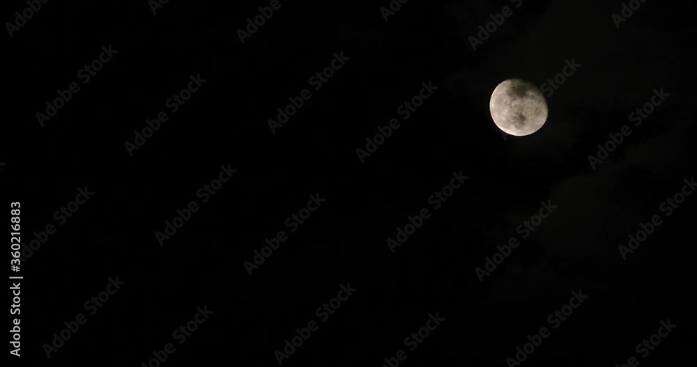 Full moon on dark cloudy night. Clouds passing by the moon in spooky feeling like thriller and horror films. Full moon on dark cloudy night. Clouds passing by the moon in spooky feeling like thriller and horror films.