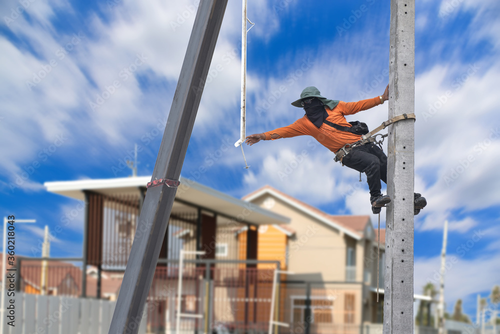 Workers climb the electric pole to install new equipment, wear safety equipment, safety belt Workers climb the electric pole to install new equipment, wear safety equipment, safety belt