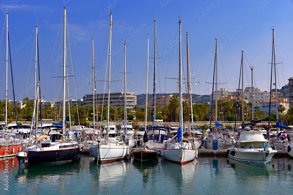 Harbor of Cannes in France with sailboat and speedboats, a city located on the French Riviera in the Alpes-Maritimes department