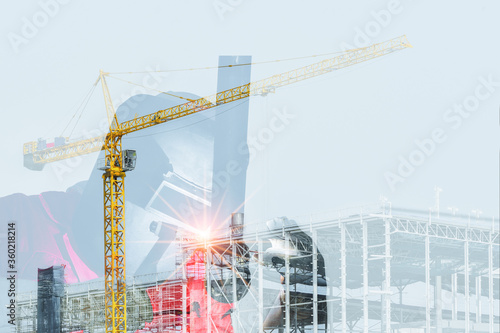 Double exposure Welder is Welding construction site with crane loading metal steel and metal structure background