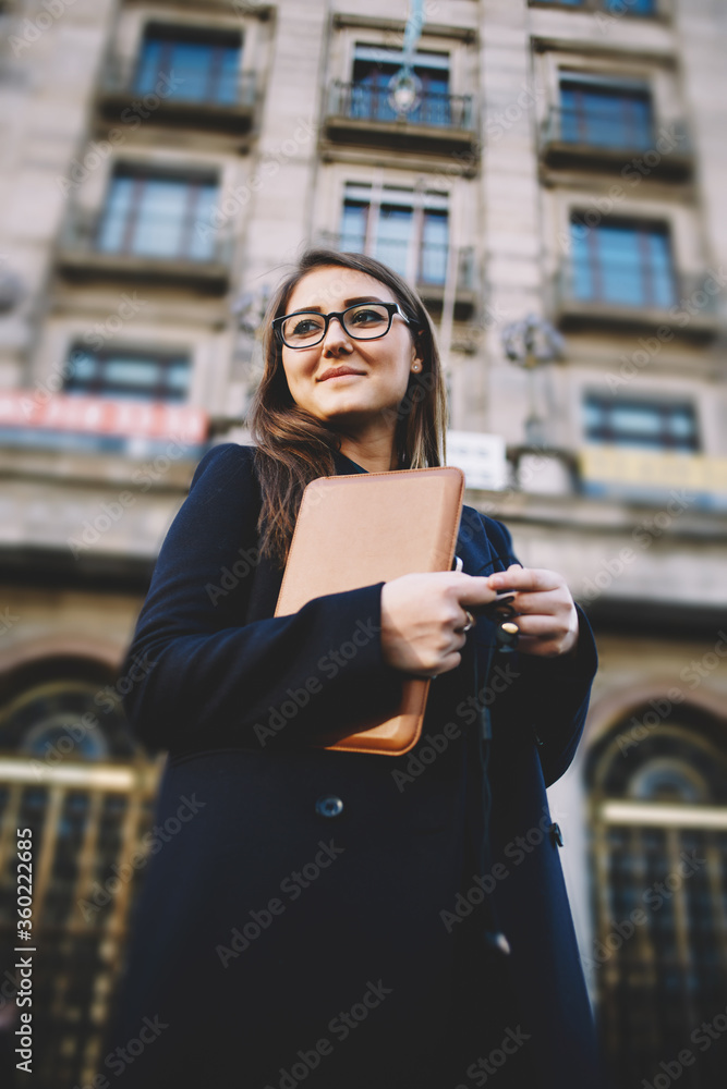 Portrait of a woman with glasses standing in the city with digital tablet in the hands Portrait of a woman with glasses standing in the city with digital tablet in the hands