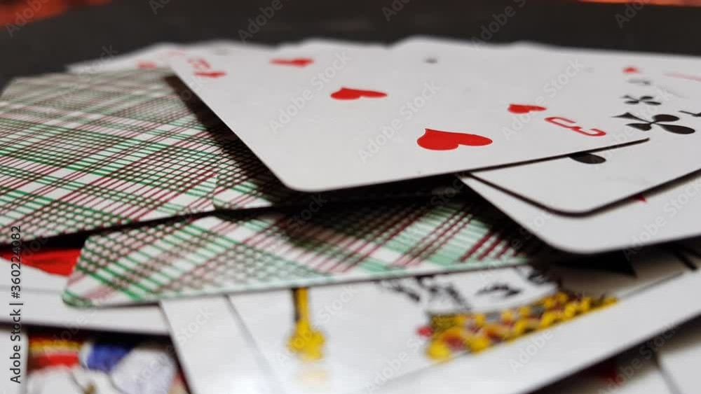 Playing cards drops on a black table, close up, side view. Playing cards drops on a black table, close up, side view.