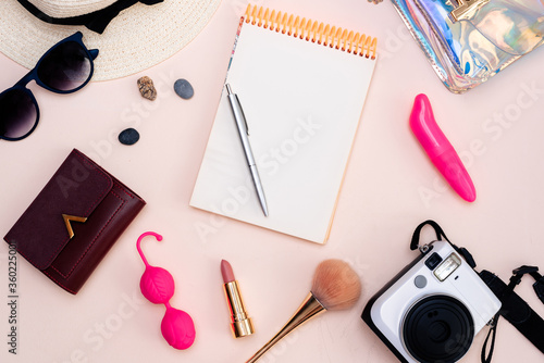 summer travel accessories. women's set of adult toys, camera, hat, glasses and top view on a light background. space for your text photo