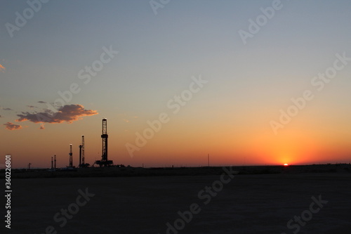 sunset over scenic West Texas landscape with FIVE drilling rigs in the background