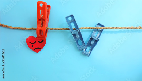 Fotografía red heart sad face on a rope on a clothespin, next to a broken clothespin