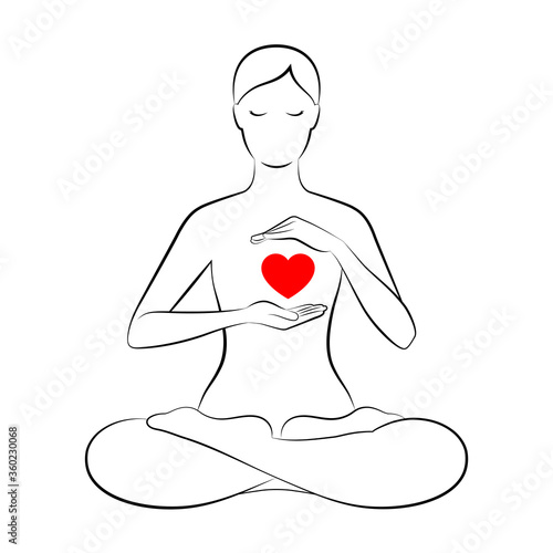 Woman is sitting in lotus position and holding hands near her heart