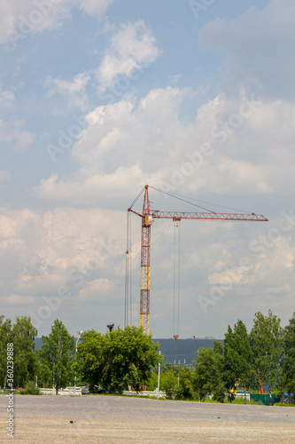 High-rise crane for construction on sky background. Tower cranes for rent with installation at construction site. Sale tower crane during economic crisis.