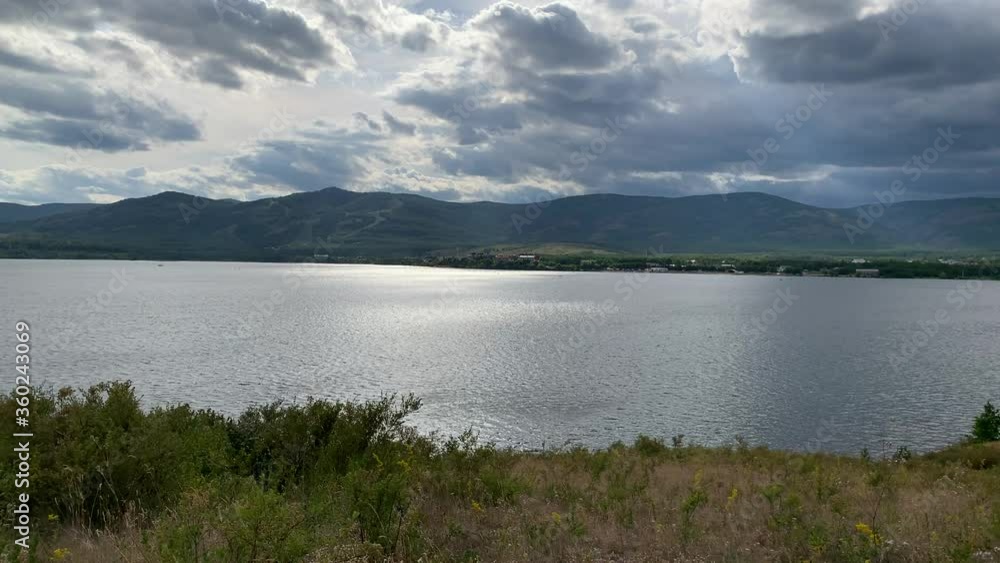 Summer landscape. Dramatic sky. Mountain lake. Beautiful blurred background. A large green field with trees and mountains in the background. A body of water with a mountain in the background Summer landscape. Dramatic sky. Mountain lake. Beautiful blurred background. A large green field with trees and mountains in the background. A body of water with a mountain in the background