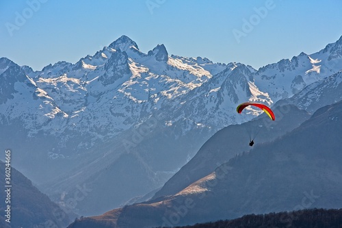 red paraglider with snowy peaks