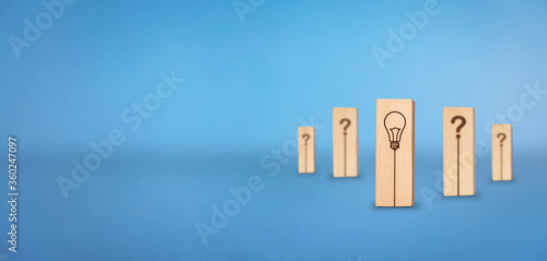 Question mark and Solution concept. Wooden block with bulb indicating solution.  