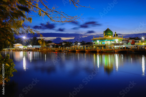 Beautiful green mosque and reflection in water and dusk sky background at Pattani,Thailand.concept for islam calendar