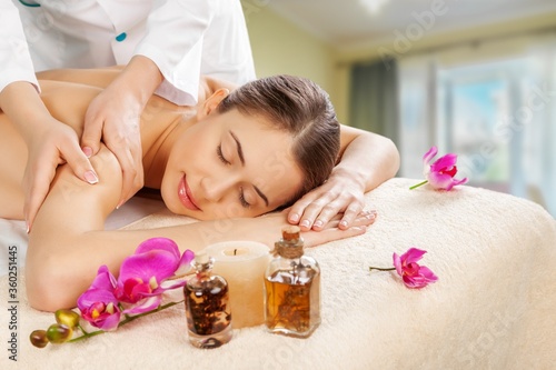 Masseur doing massage on beautiful woman body in the spa salon.