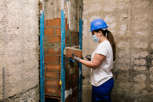 woman with a mask working on a house renovation 