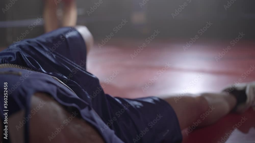 Legs of two boxers fighting on boxing ring and man in blue uniform ...