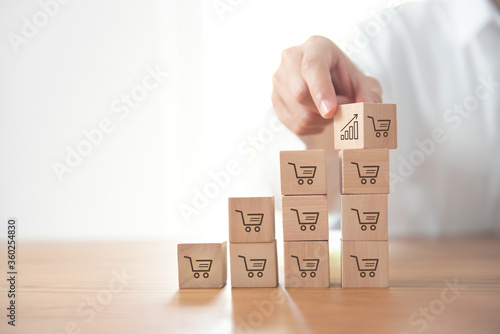 sale volume increase make business grow, businesswoman flips cube with icon graph and shopping cart symbol.